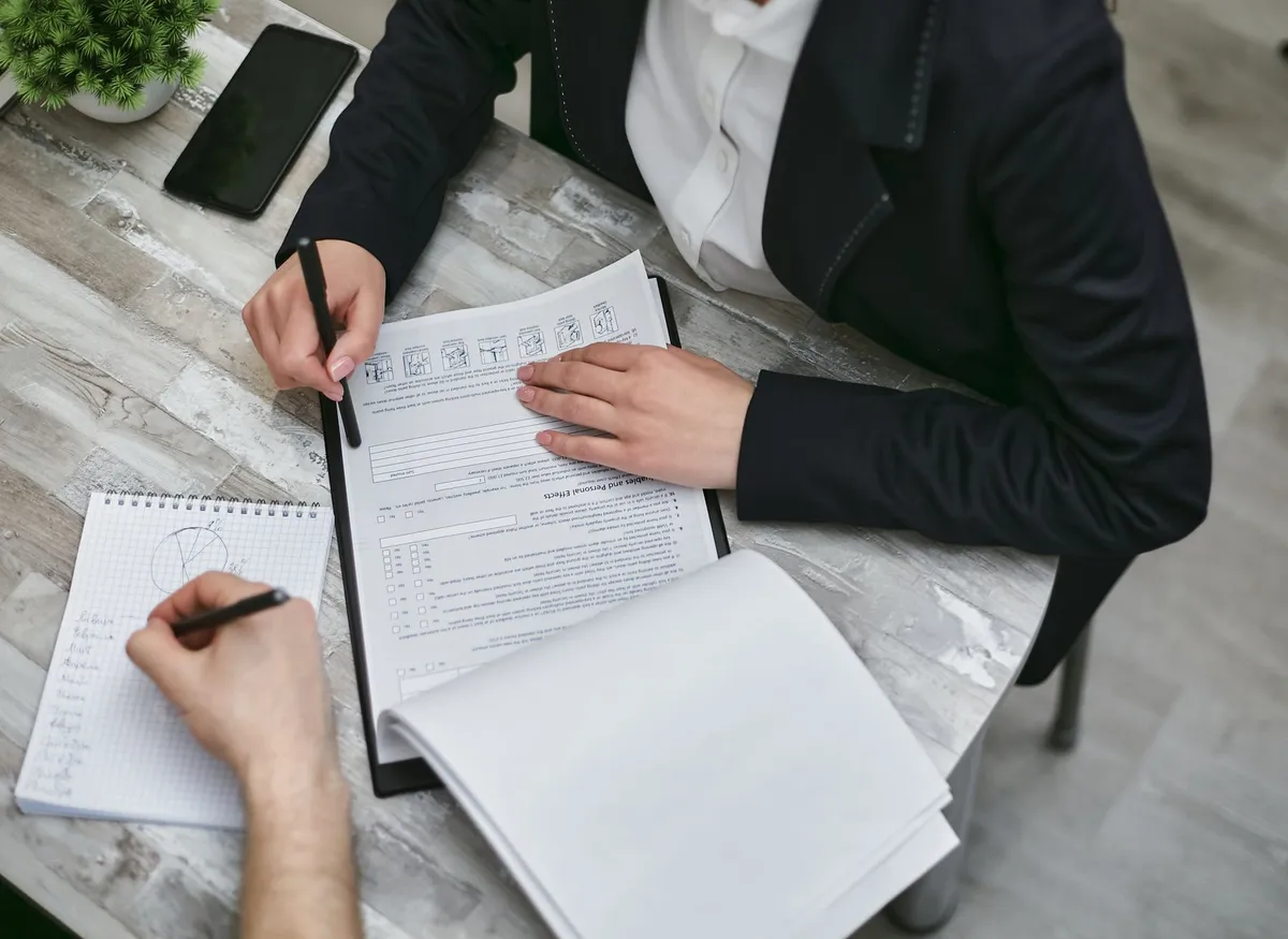 Vista cenital de dos profesionales completando un formulario de relevamiento sobre una mesa